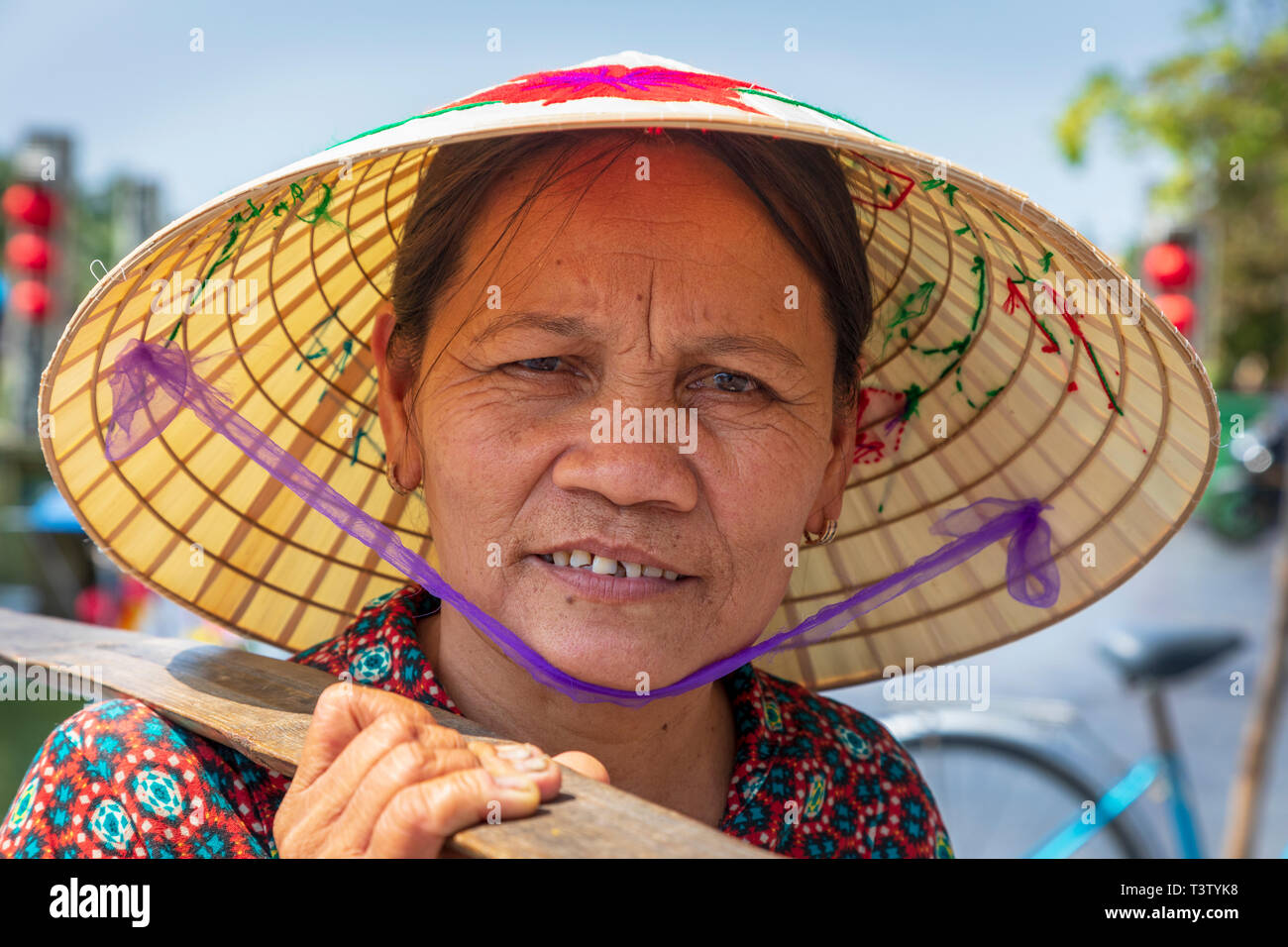 Portrait eines älteren Vietnamesin Tragen eines traditionellen Sampan hat auch als "Reis hat' bekannt. Hoi An, Quang Nam, Vietnam, Asien Stockfoto