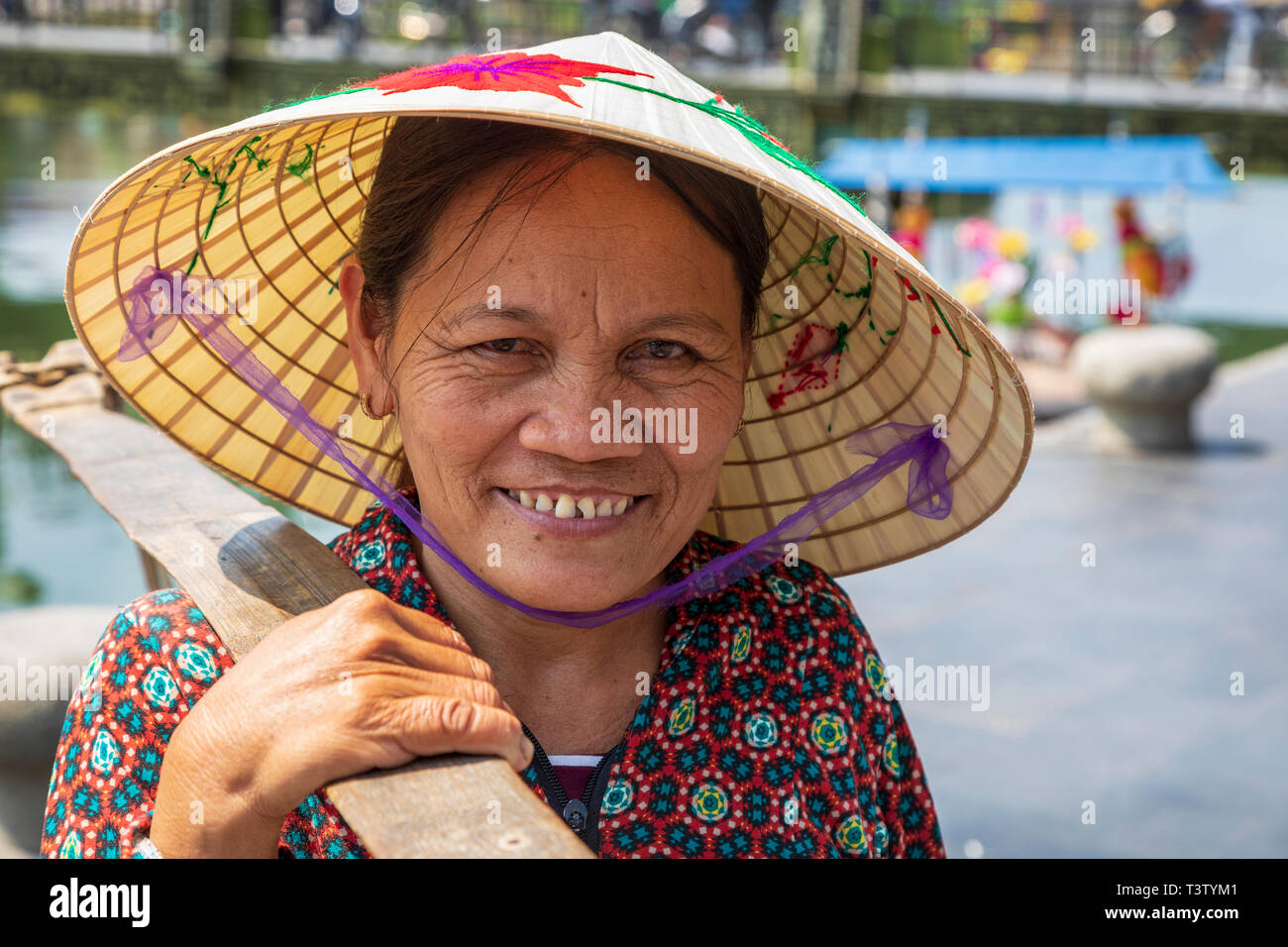 Portrait eines älteren Vietnamesin Tragen eines traditionellen Sampan hat auch als "Reis hat' bekannt. Hoi An, Quang Nam, Vietnam, Asien Stockfoto