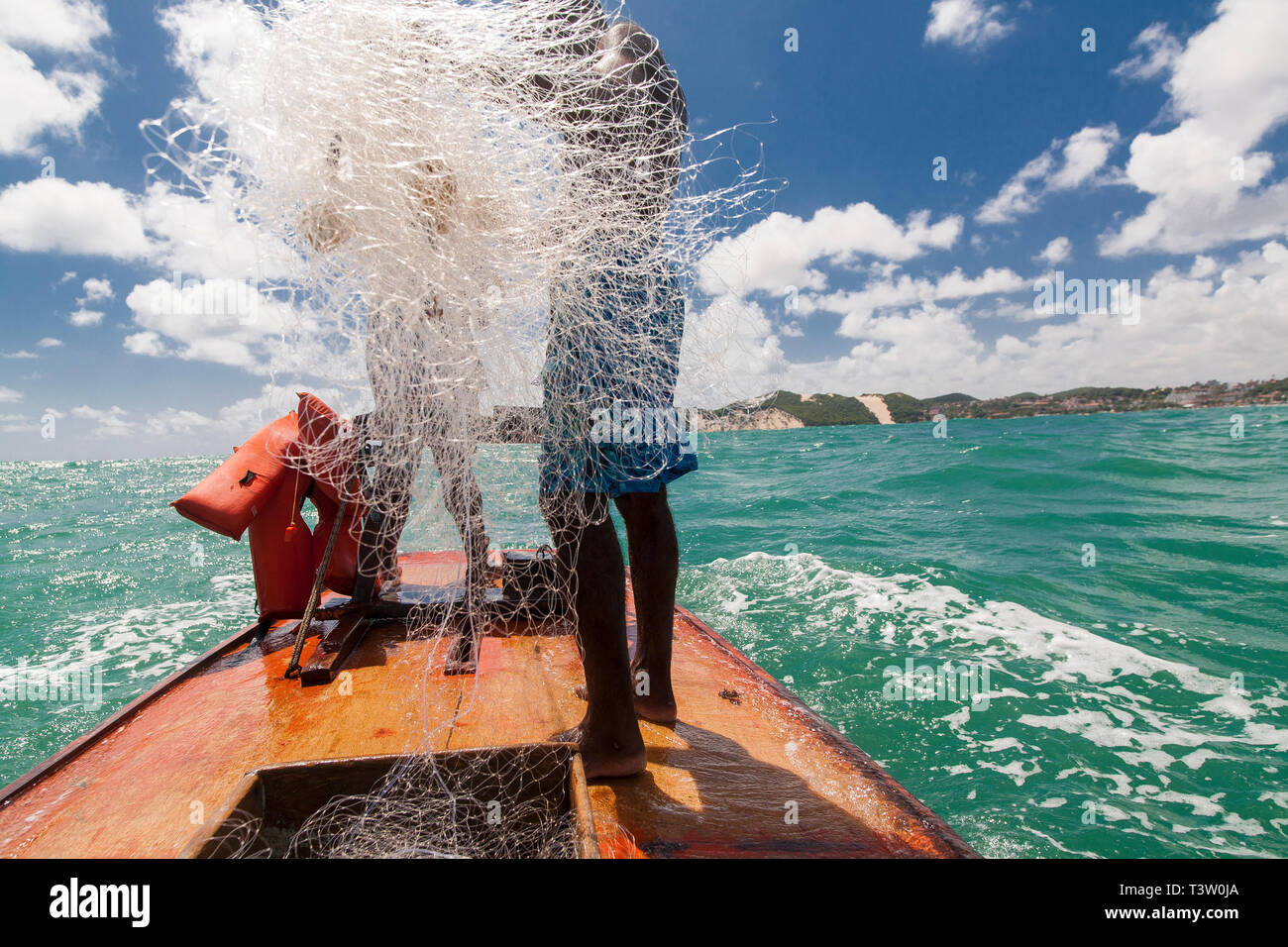 Angeln in einem jangada - seaworth Segeln floß von den Fischern der Nordosten Brasiliens verwendet. Ponta Negra Beach, Natal, Rio Grande Norte Zustand tun. Morro do Careca, Natal Wahrzeichen, im Hintergrund. Stockfoto