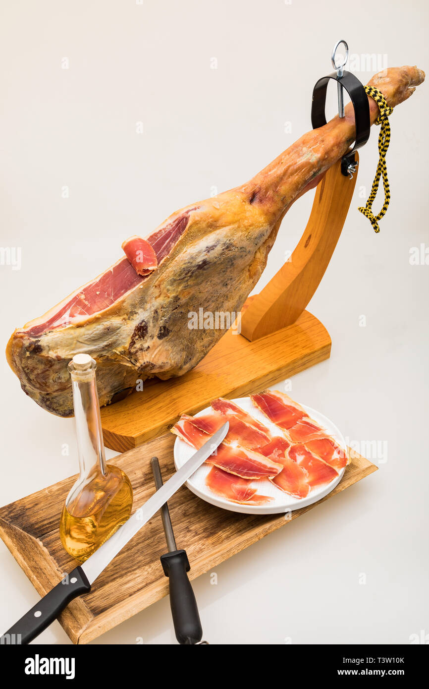 Spanischer Serrano Schinken auf das Bein mit Holz Halter - isoliert Stockfoto