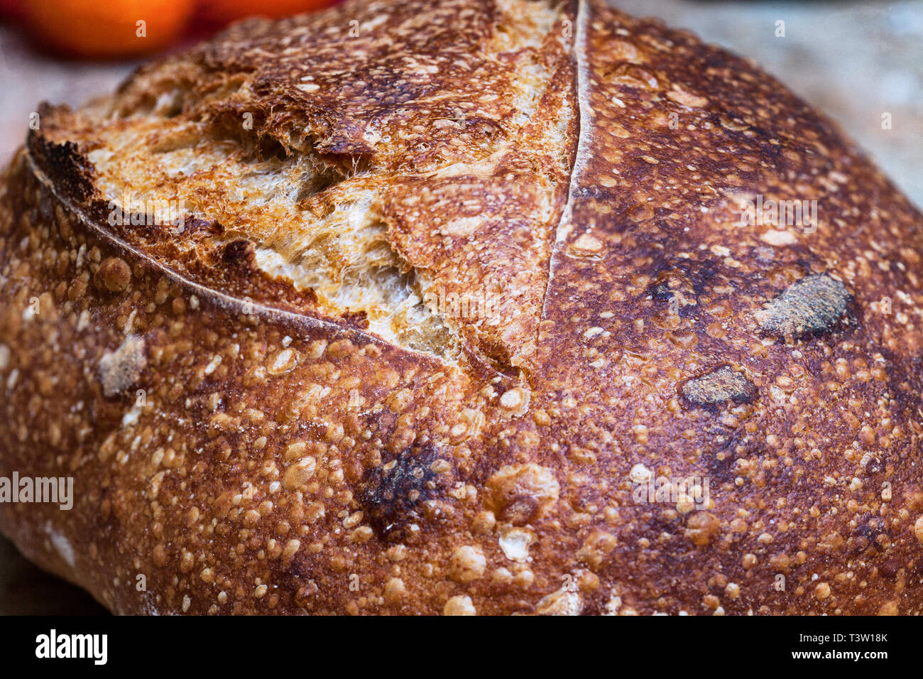 Knuspriges Brot von frisch gebackenem Sauerteigbrot Boule. Scheiben von sauerteigbrot auf Holzbrett. Gesundes Essen. Artisan Brot Krume Textur Stockfoto