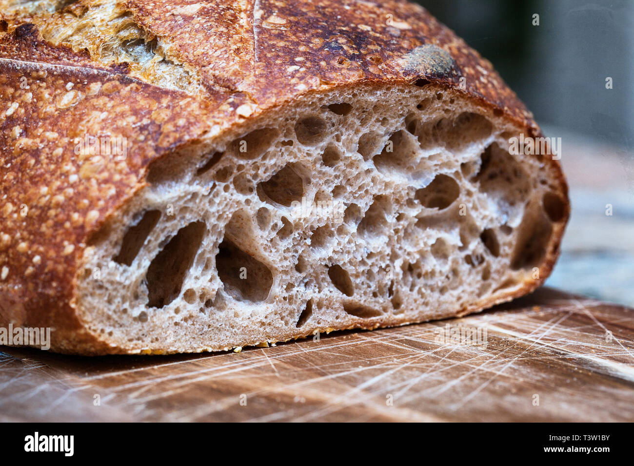 Knuspriges Brot von frisch gebackenem Sauerteigbrot Focaccia. Scheiben von sauerteigbrot auf Holzbrett. Gesundes Essen. Artisan Brot Krume Textur close-up Stockfoto