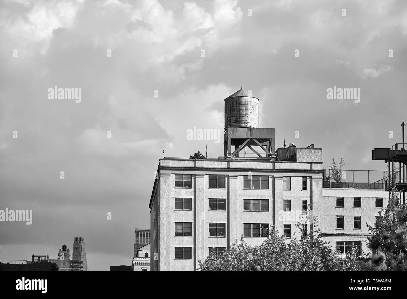 Schwarz-weiß Bild von einem Wasserturm auf einem Gebäude auf dem Dach, New York City, USA. Stockfoto
