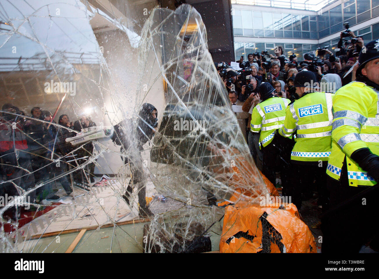 Studenten smash das Lobby Fenster in Millbank Tower, Konservative Partei HQ. Demo gegen die Pläne zu Studiengebühren und Kürzungen der Universität Finanzierung erhöhen. Lo Stockfoto