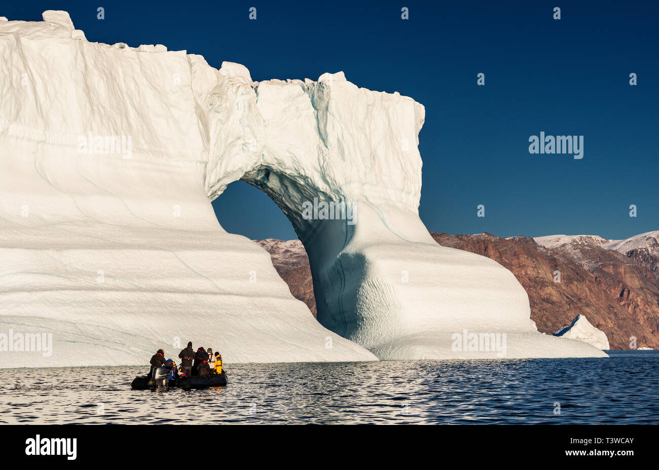 Tourist in einem Floß durch die Eisberge, Scoresbysund, Grönland Stockfoto