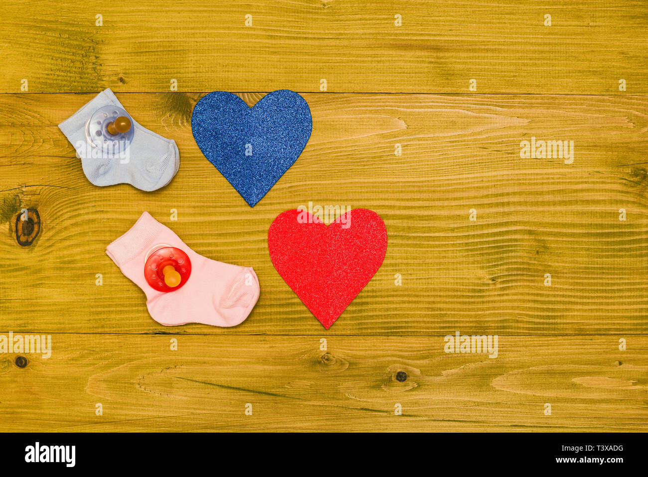 Baby Zubehör für Jungen und Mädchen und Herz Formen auf Holztisch. Baby Ankündigung Konzept. Getönten Foto. Stockfoto