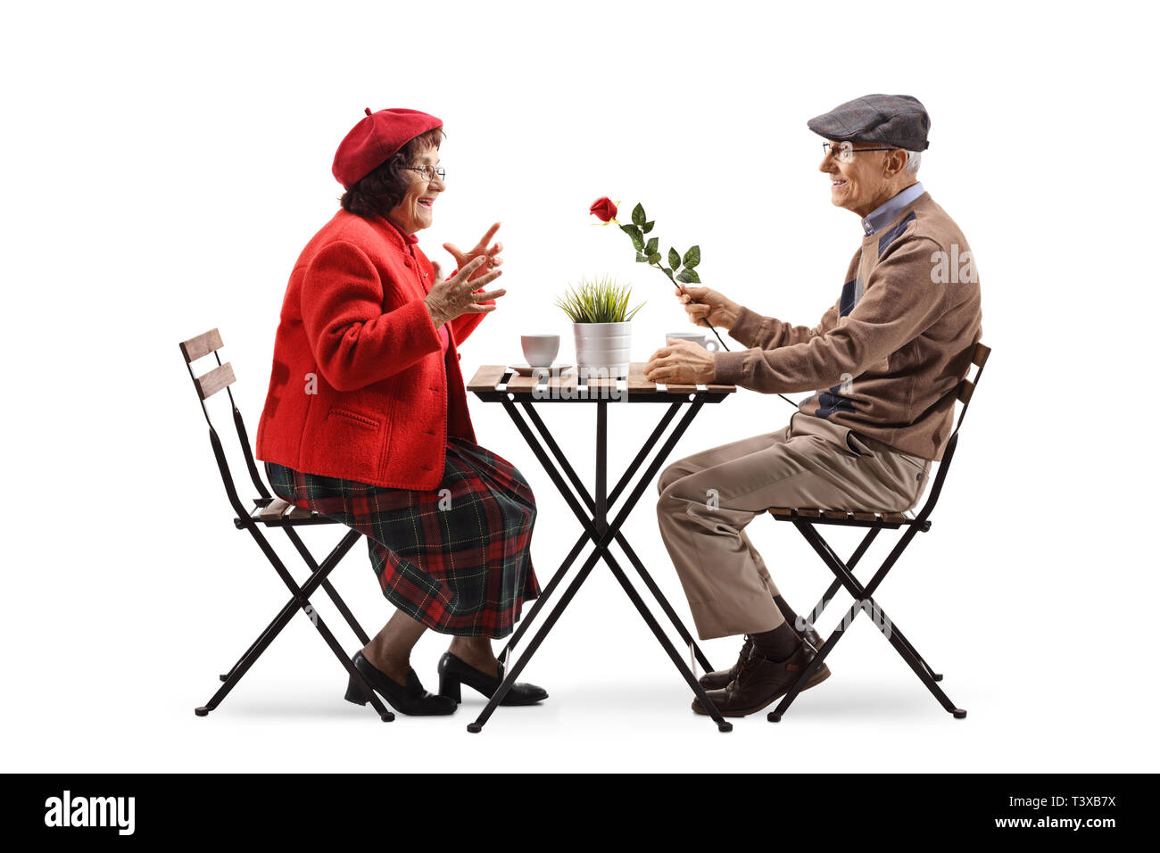 Volle Länge Profil geschossen von einem älteren Mann in einem Café sitzen und eine rote Rose zu einer älteren Dame auf weißem Hintergrund Stockfoto