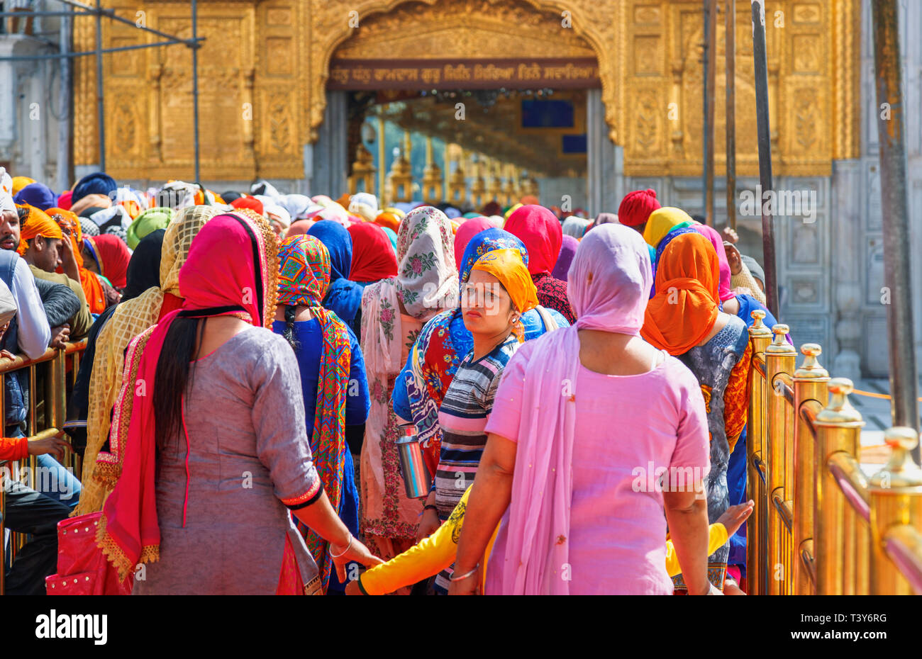 Lokale Sikhs Queuing auf dem Damm der Sanctum Sanctorum der Goldenen Tempel von Amritsar, dem heiligsten Wallfahrtsort des Sikhismus eingeben Stockfoto