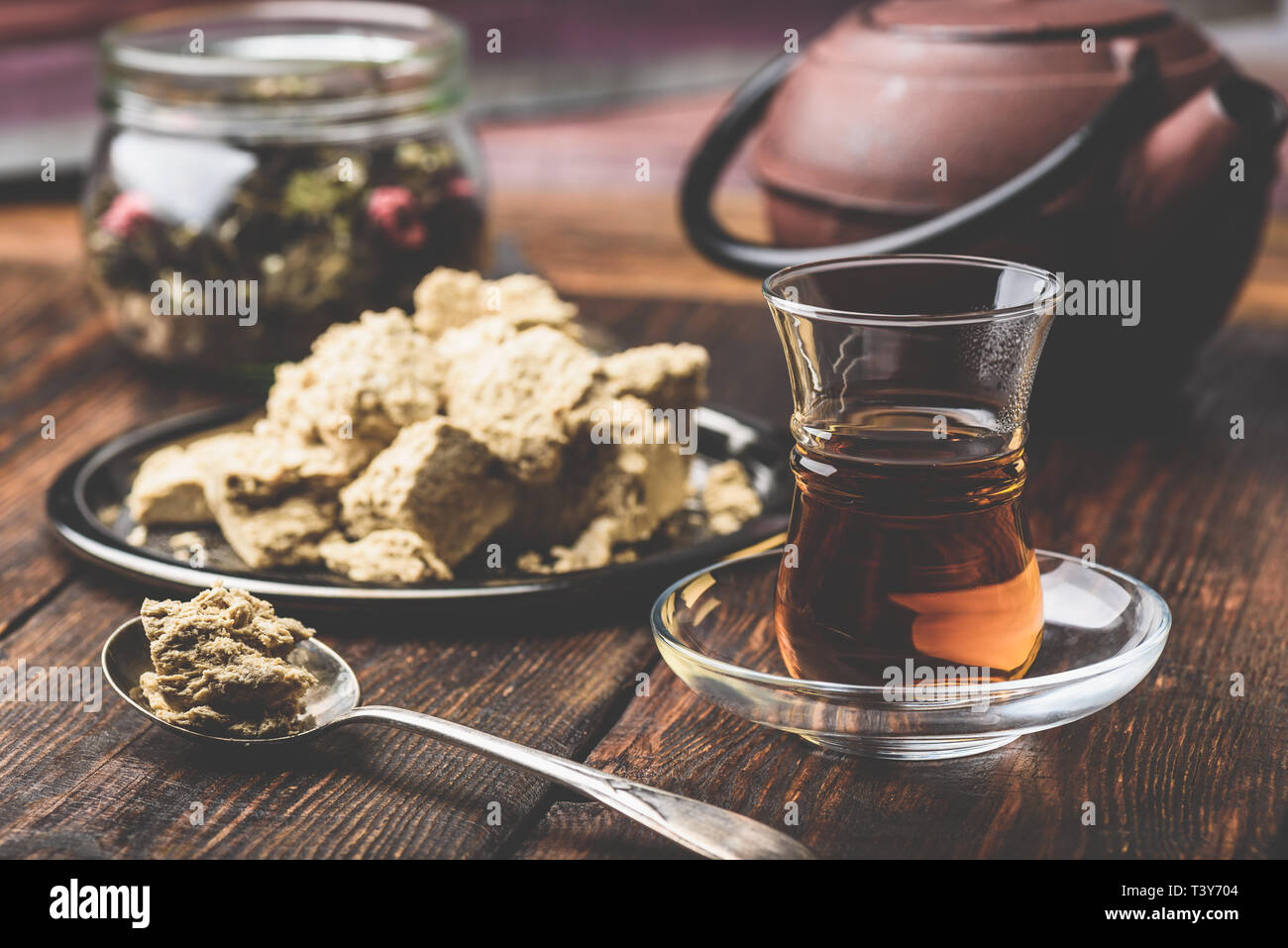 Schwarzer Tee in armudu Glas und Löffel Sonnenblumenöl halva Stockfoto