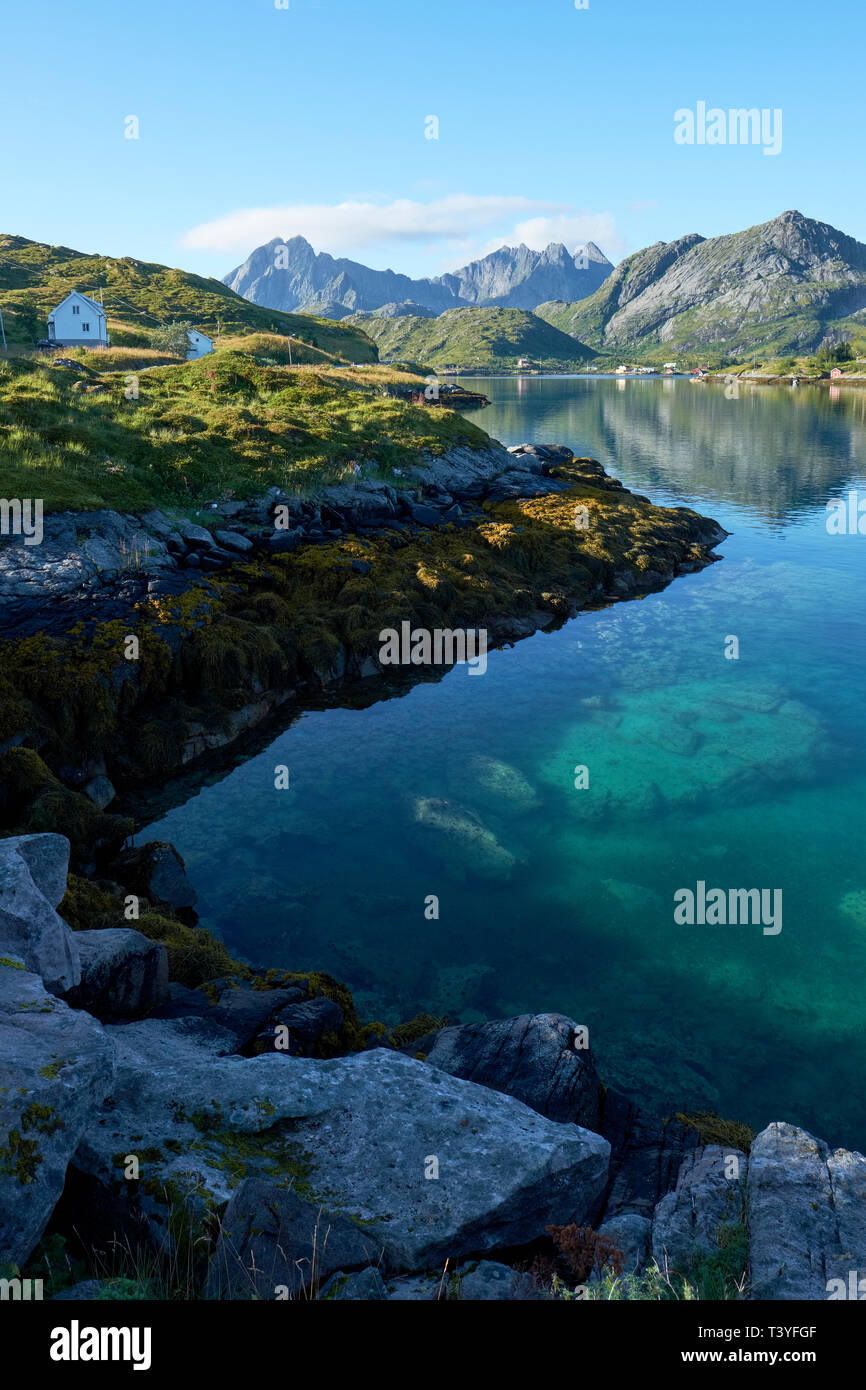 Das klare Wasser der Küste und Berge im Sommer Landschaft von Flakstadoya und Moskenesøya in die Lofoten Nordland in Norwegen. Stockfoto