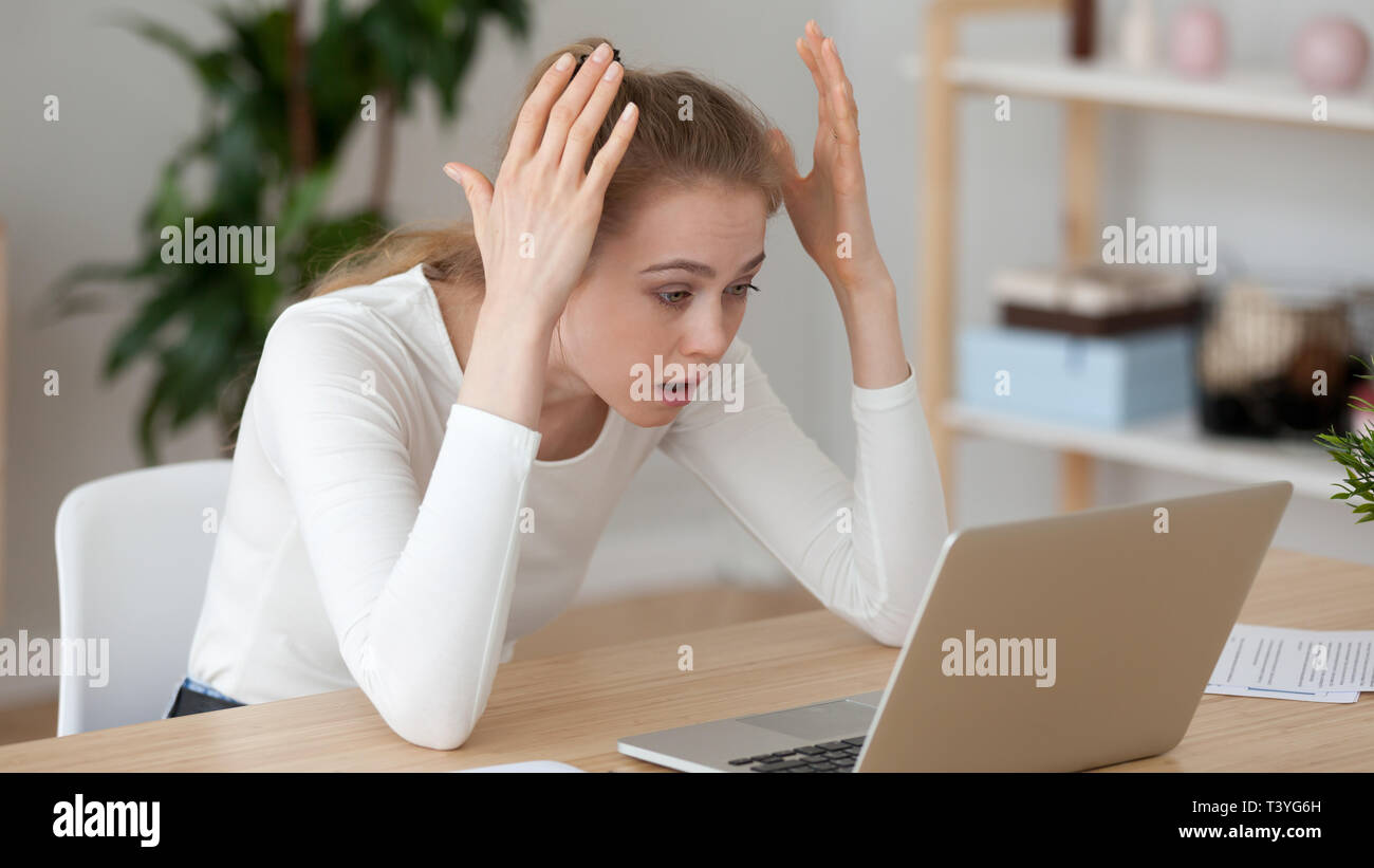 Wütend genervt junge Frau mit Laptop suchen, Empfangen von schlechten Nachrichten Stockfoto