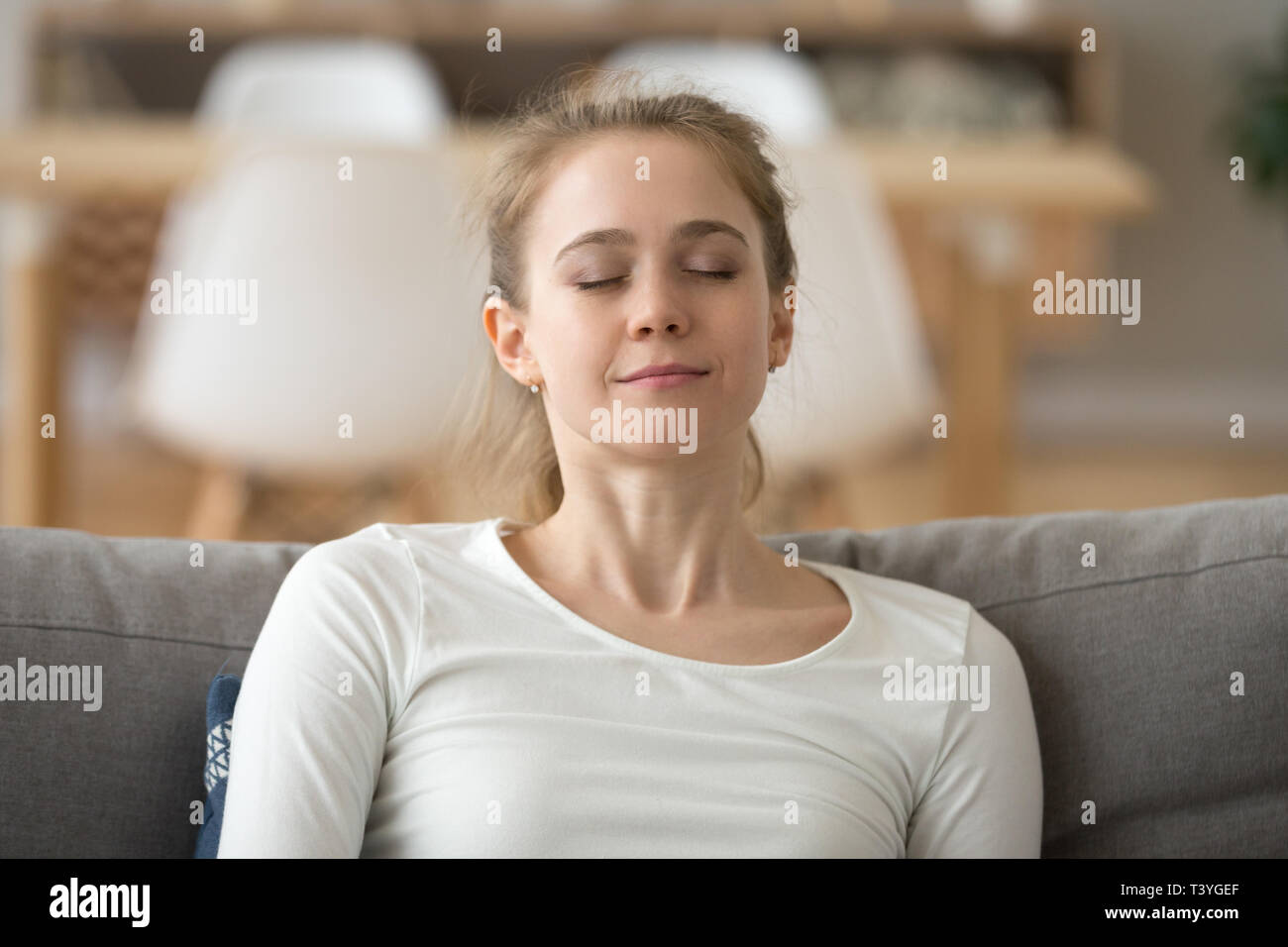 In der Nähe von ruhigen friedlichen Frau entspannt mit geschlossenen Augen auf dem Sofa Stockfoto