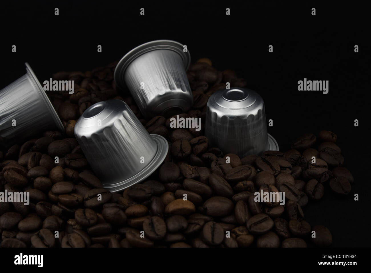 Espresso Kaffee Kapseln oder Kaffeepads auf Kaffeebohnen, schwarzen Hintergrund. Kapseln für die Kaffeemaschine. Stockfoto