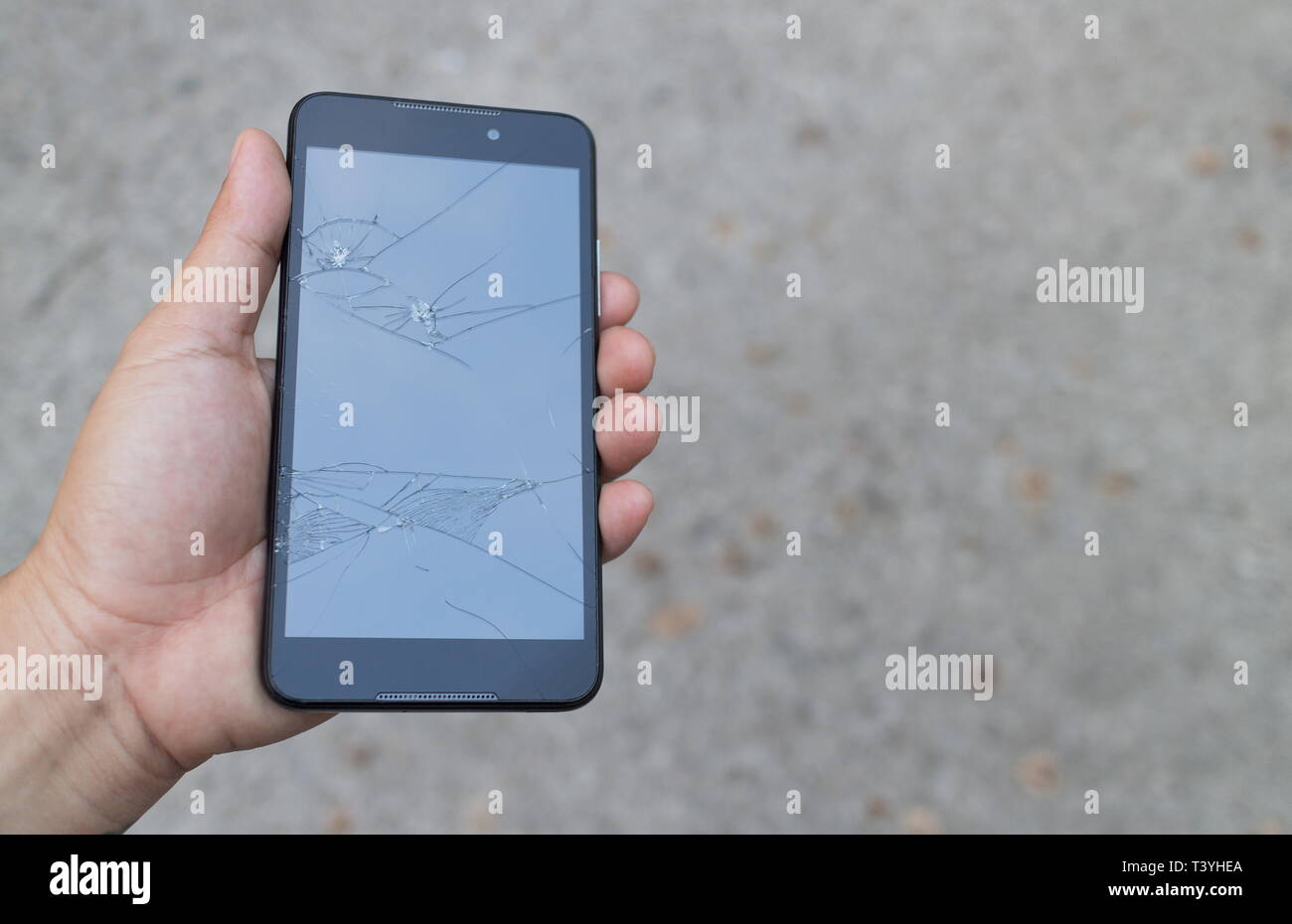 Mann mit einem gebrochenen Smartphone und Schäden am Bildschirm kaputt Touch. Stockfoto