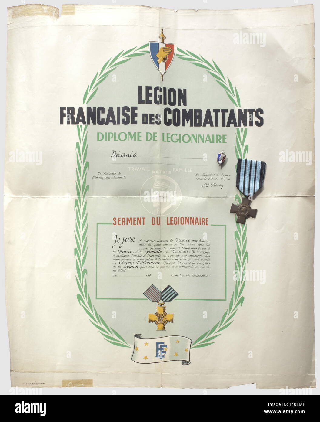 DEUXIEME GUERRE MONDIALE ET FRANKREICH OCCUPEE, Légion Francaise des Beteiligten, Diplôme de Légionnaire, serment du Légionnaire. Dokument vierge avec son Insigne de la Maison "J. Decat Auvergne Vichy'et sa Croix du Combattant de Vichy, marquée au Dos 1939-1940 (petite déchirure), Editorial-Use - Nur Stockfoto