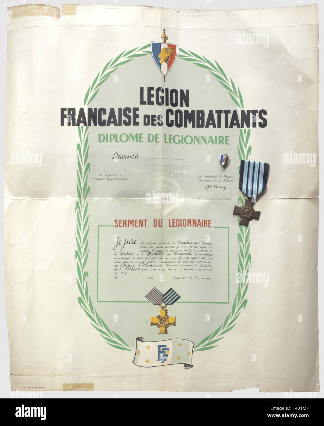 DEUXIEME GUERRE MONDIALE ET FRANKREICH OCCUPEE, Légion Francaise des Beteiligten, Diplôme de Légionnaire, serment du Légionnaire. Dokument vierge avec son Insigne de la Maison "J. Decat Auvergne Vichy'et sa Croix du Combattant de Vichy, marquée au Dos 1939-1940 (petite déchirure), Editorial-Use - Nur Stockfoto