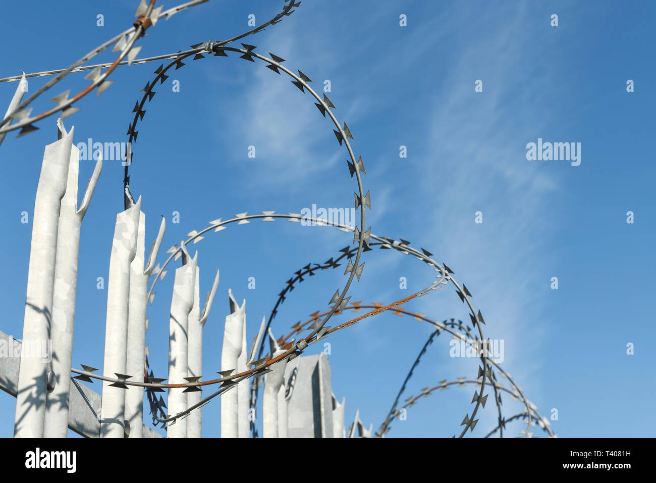 Nahaufnahme Detail der Stacheldraht auf einer metallenen Zaun vor blauem Himmel Stockfoto