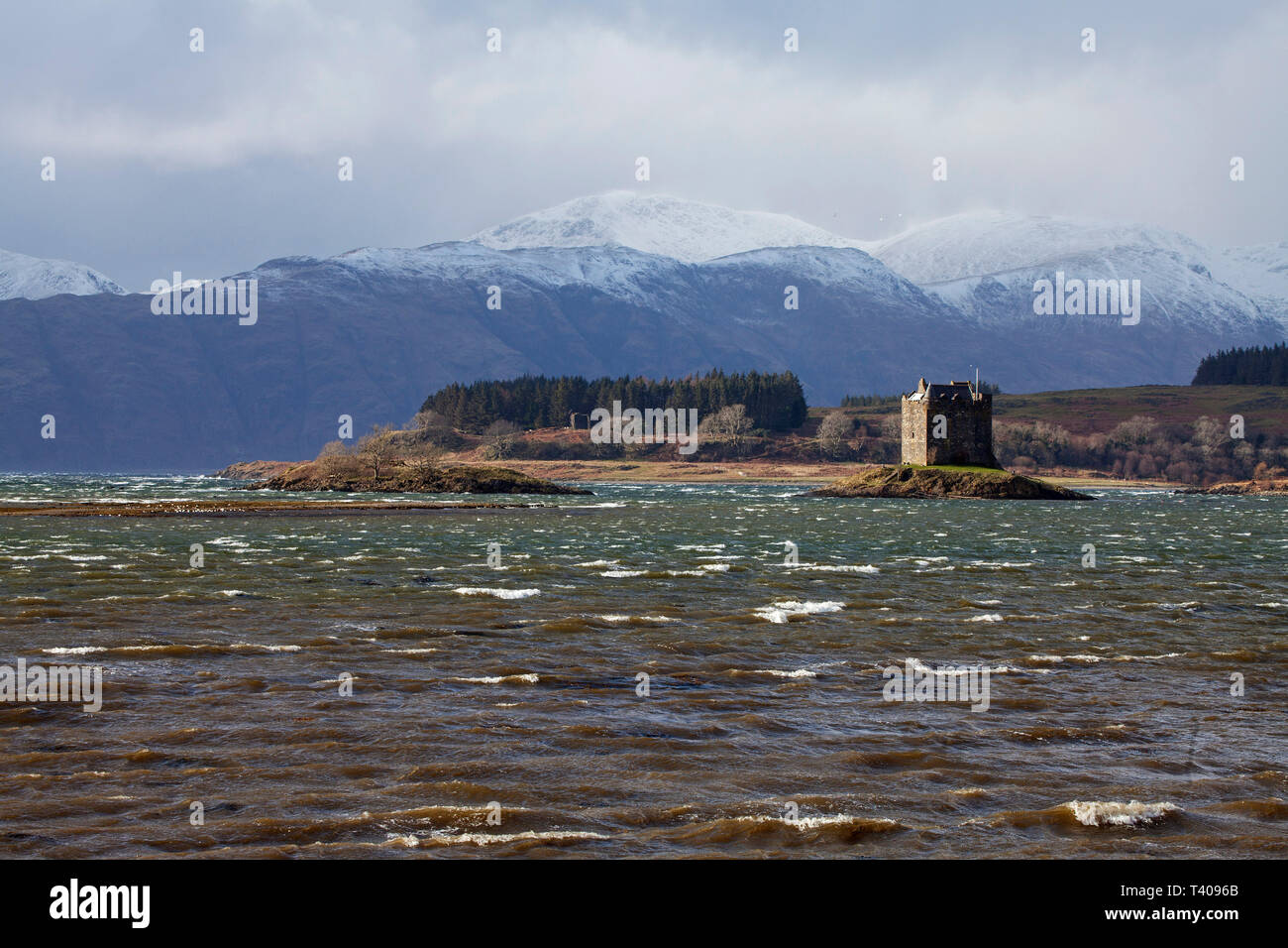 Castle Stalker in der Gezeiten Einlass des Loch Laich ein Einlaß des Loch Linnhe mit der schneebedeckten Berge jenseits Highland Region Argyll und Bute Scotlan Stockfoto