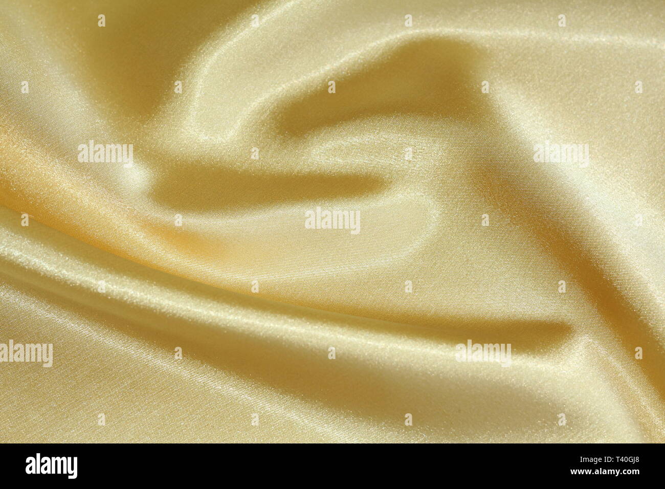 Die Textur der gelb Material. Heller gelber Seide. Goldener Hintergrund. Stockfoto