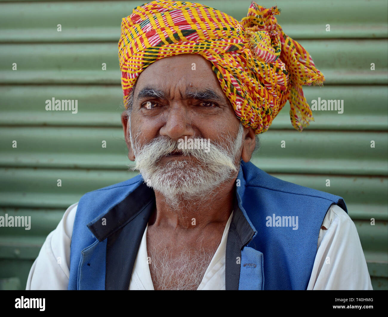 Ältere indische Rajasthani Mann mit einem bunten Turban headwrap posiert für die Kamera. Stockfoto