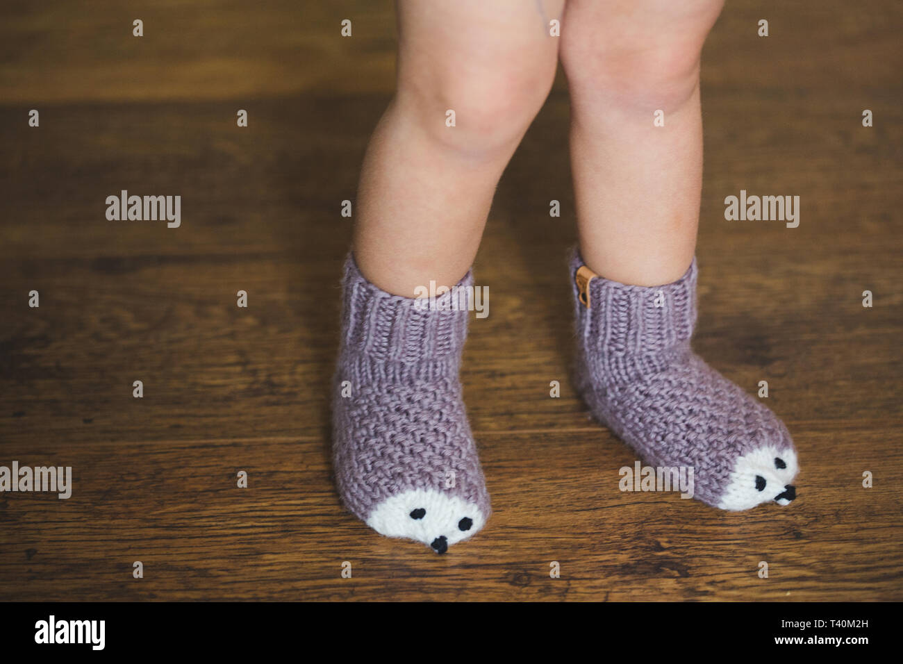 Baby Füße im Winter igel Socken auf Holz- Hintergrund Stockfotografie -  Alamy