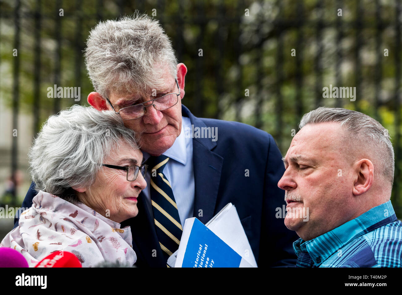 Kate McCausland (links) ist umarmt von Überlebenden North West Jon McCourt (Mitte) und von John heaney (rechts) nach dem Gespräch ihrer Mutter Una Irvine außerhalb des Belfaster Gericht mit Opfer und Familien von Opfern der historischen institutionellen Missbrauch, nach einer fehlgeschlagenen Angebot zu zwingen, das Nordirland Staatssekretär Karen Bradley zu jenen missbraucht kompensieren begleitet. Stockfoto