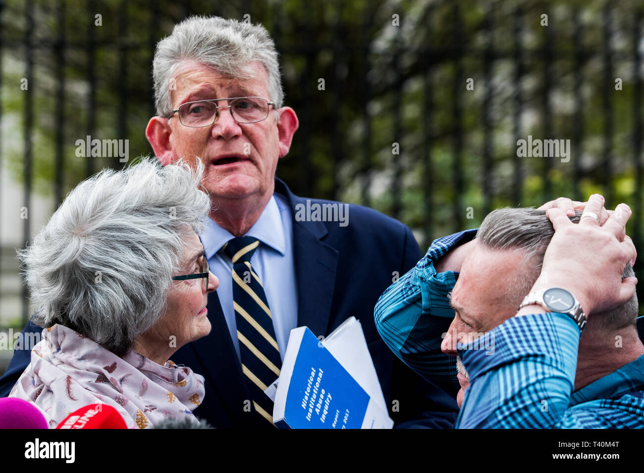 Kate McCausland (links) ist umarmt von Überlebenden North West Vorsitzender Jon McCourt (Mitte) und von John heaney (rechts) nach dem Gespräch ihrer Mutter Una Irvine außerhalb des Belfaster Gericht mit Opfer und Familien von Opfern der historischen institutionellen Missbrauch, nach einer fehlgeschlagenen Angebot zu zwingen, das Nordirland Staatssekretär Karen Bradley zu jenen missbraucht kompensieren begleitet. Stockfoto