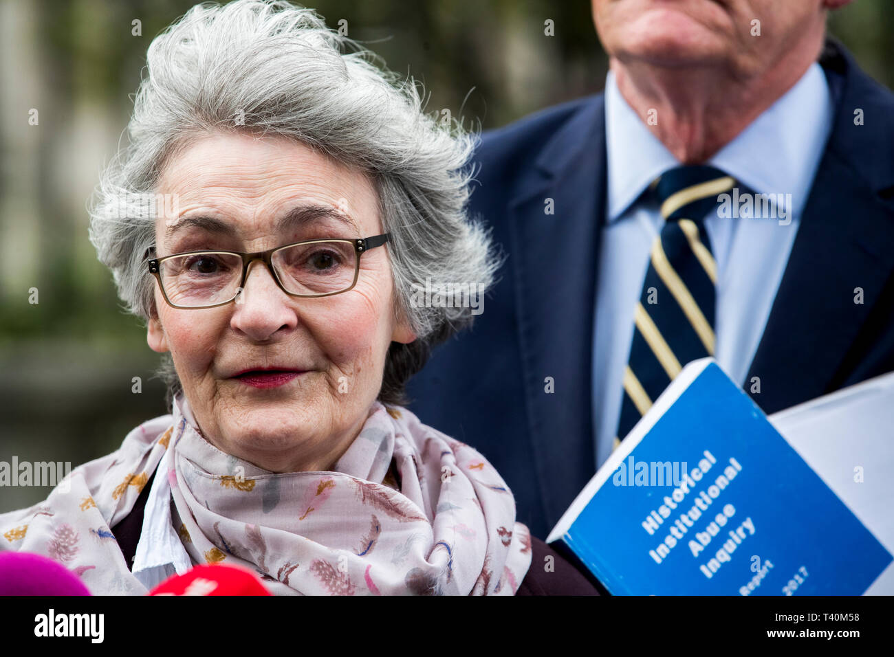 Kate McCausland spricht von ihrer Mutter Una Irvine außerhalb des Belfaster Gericht mit Opfer und Familien von Opfern der historischen institutionellen Missbrauch, nach einer fehlgeschlagenen Angebot zu zwingen, das Nordirland Staatssekretär Karen Bradley zu jenen missbraucht kompensieren. Stockfoto