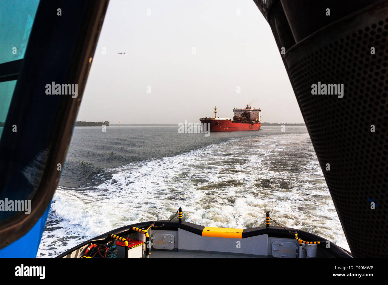 Port Operations Management und den Transport von Eisenerz. Von führenden Tauziehen um transhipper oder TSV im Versand Kanal OGV ocean gehen Schiff auf dem Meer zu erfüllen Stockfoto