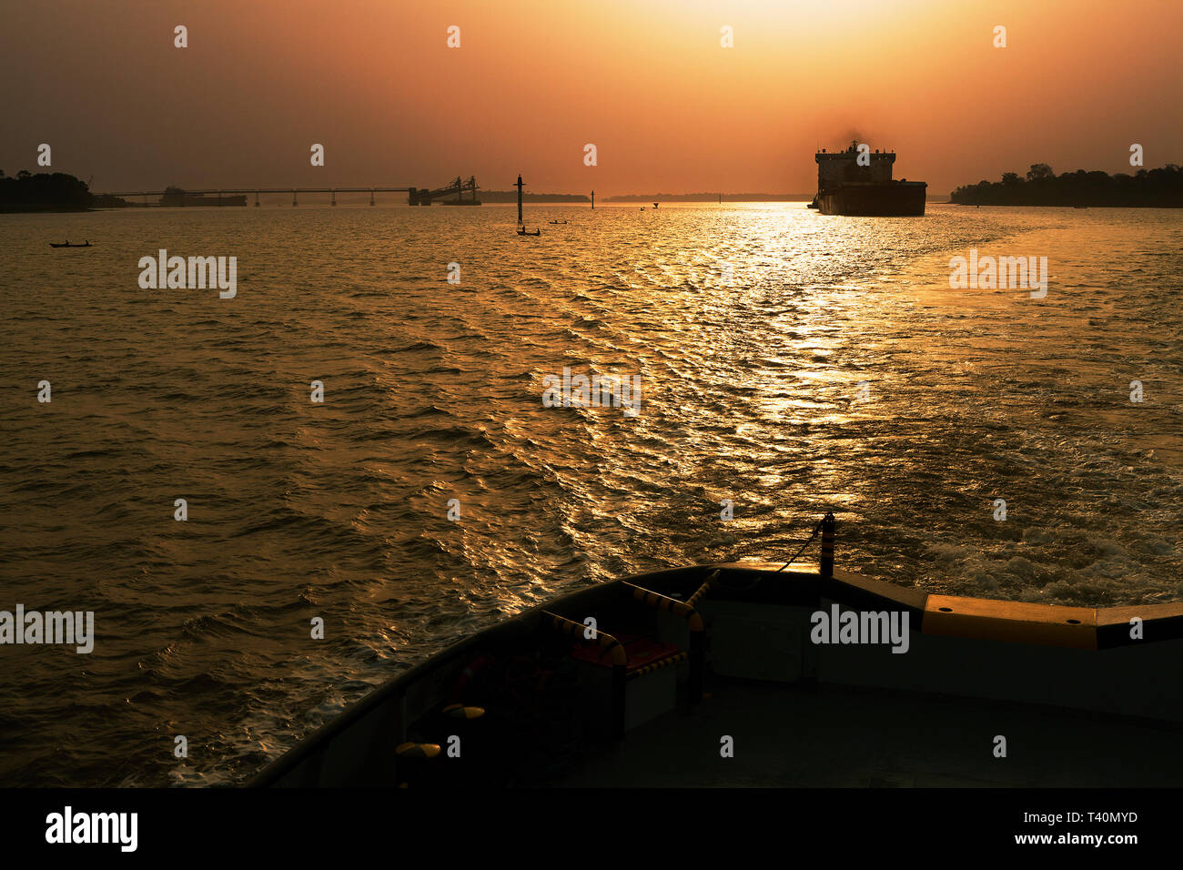 Dämmerung am Port Operations Management und den Transport von Eisenerz. Von führenden Tauziehen um transhipper oder TSV im Versand Kanal OGV Ozean Schiff zu erfüllen Stockfoto