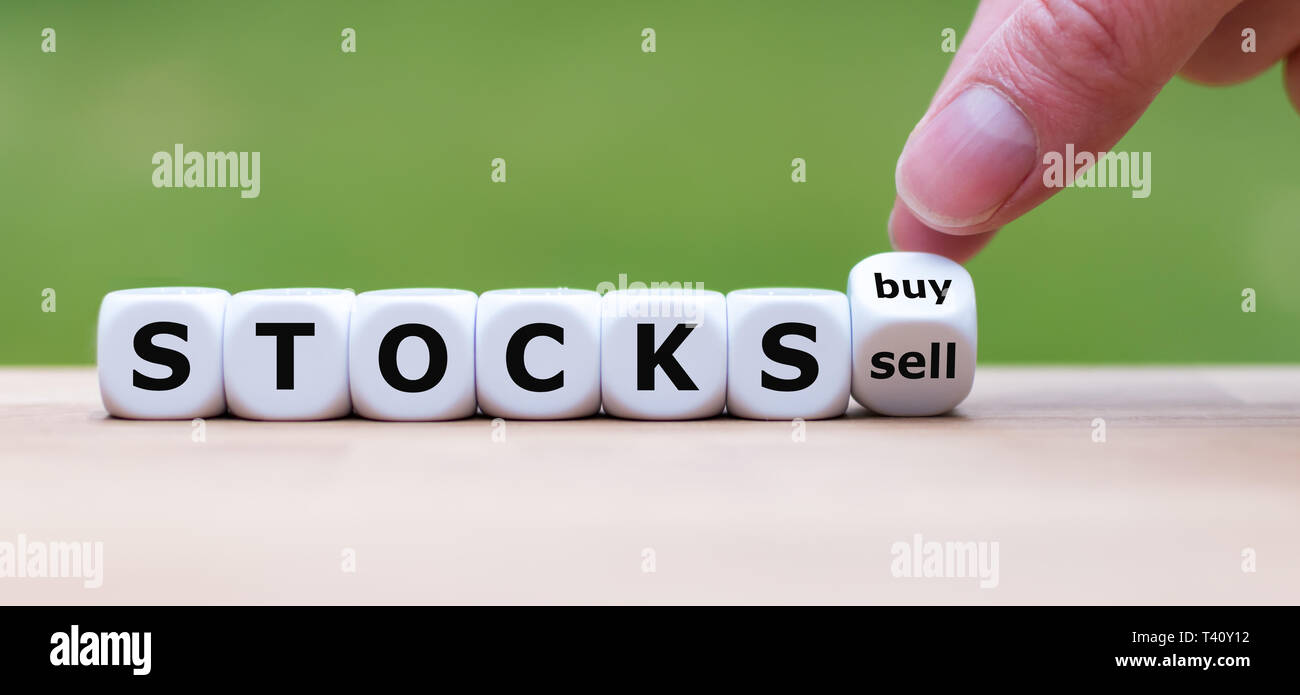 Symbol für den Kauf oder Verkauf von Aktien. Hand einen Würfel und Änderungen ell das Wort' auf 'Kaufen'. Stockfoto