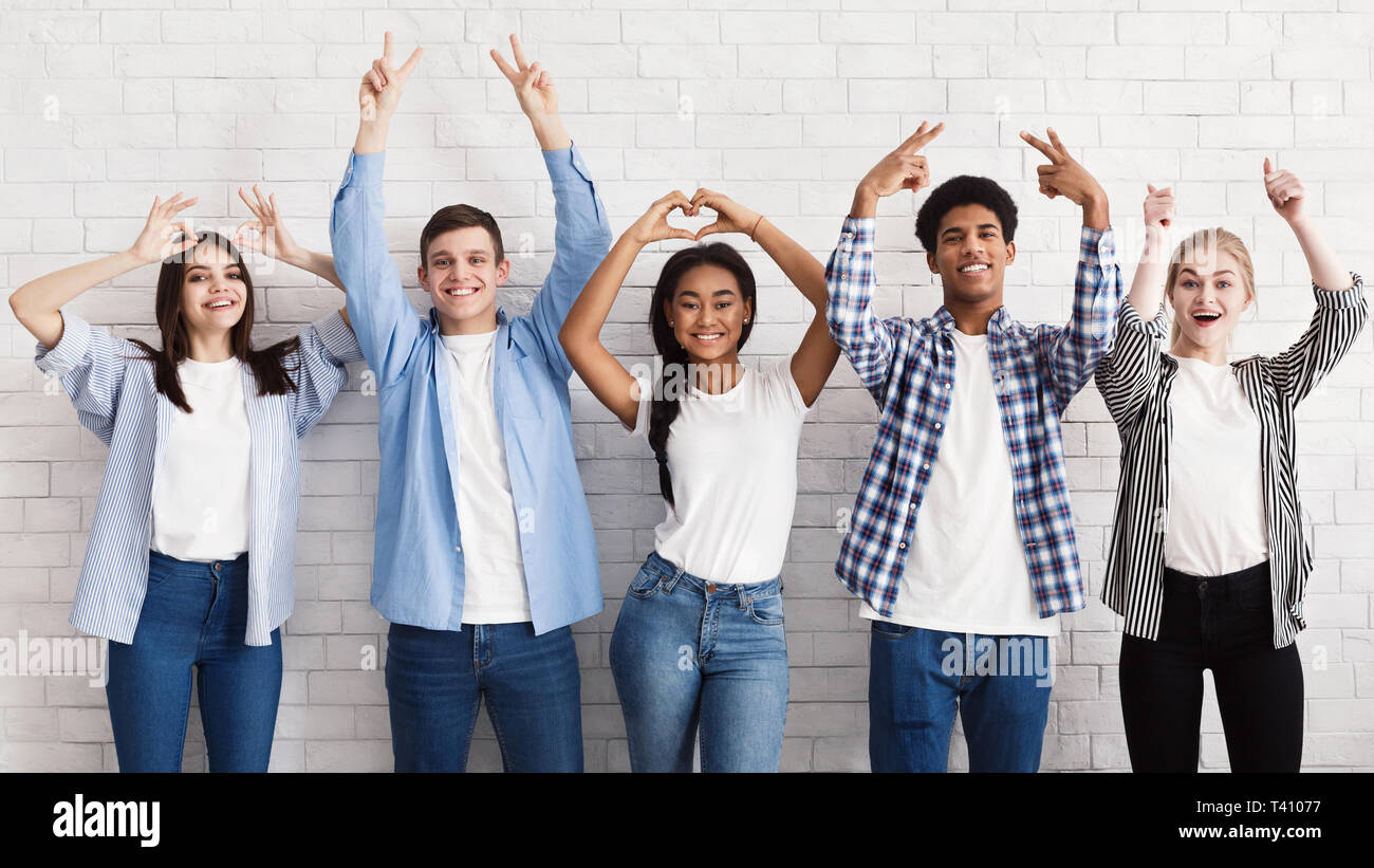 Teen Freunde gestikulierte mit Händen über weiße Wand Stockfoto