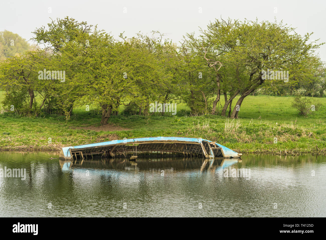 Die Hälfte unter Wasser Boot Wrack am Ufer eines Flusses Stockfoto