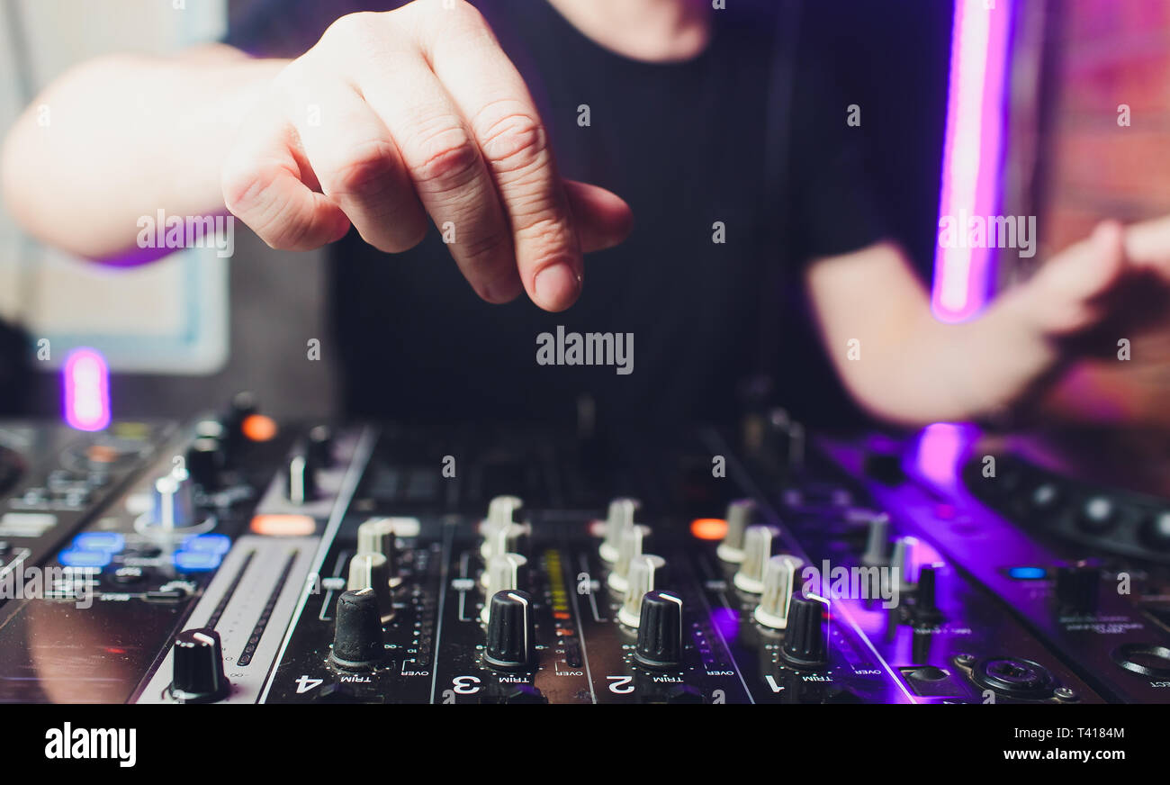 Nahaufnahme der Hände der männlichen disc jockey Mischen Musik auf seinem Deck mit seinen Händen über die Schallplatte auf den Plattenteller und die Kontrolle balanciert Stockfoto