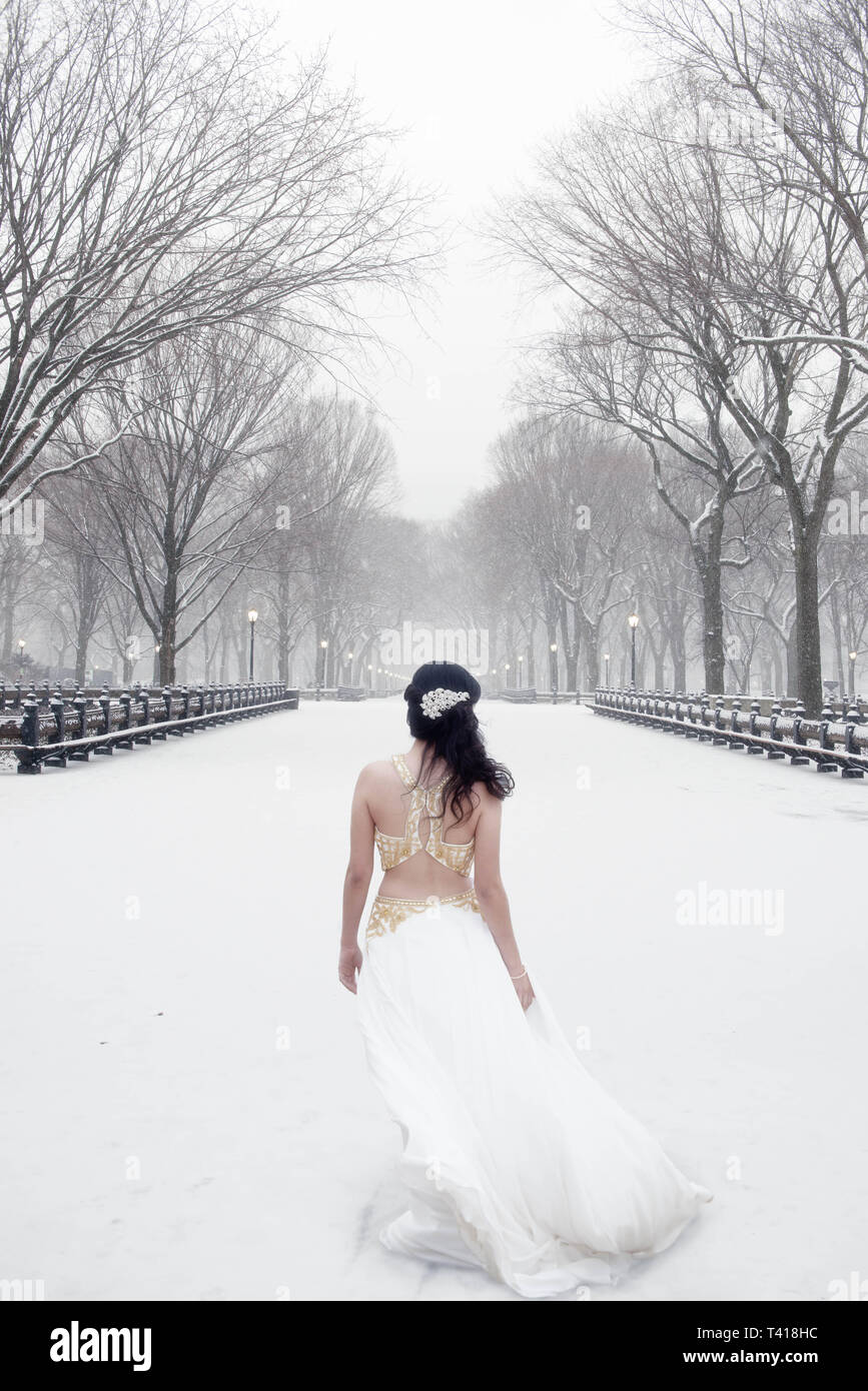 Frau, gekleidet in ein weißes Kleid im Schnee, Central Park, Manhattan, New York, United States Stockfoto