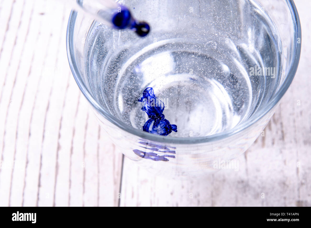 Blaue Tinte in Wasser Glas und Pipette Stockfoto