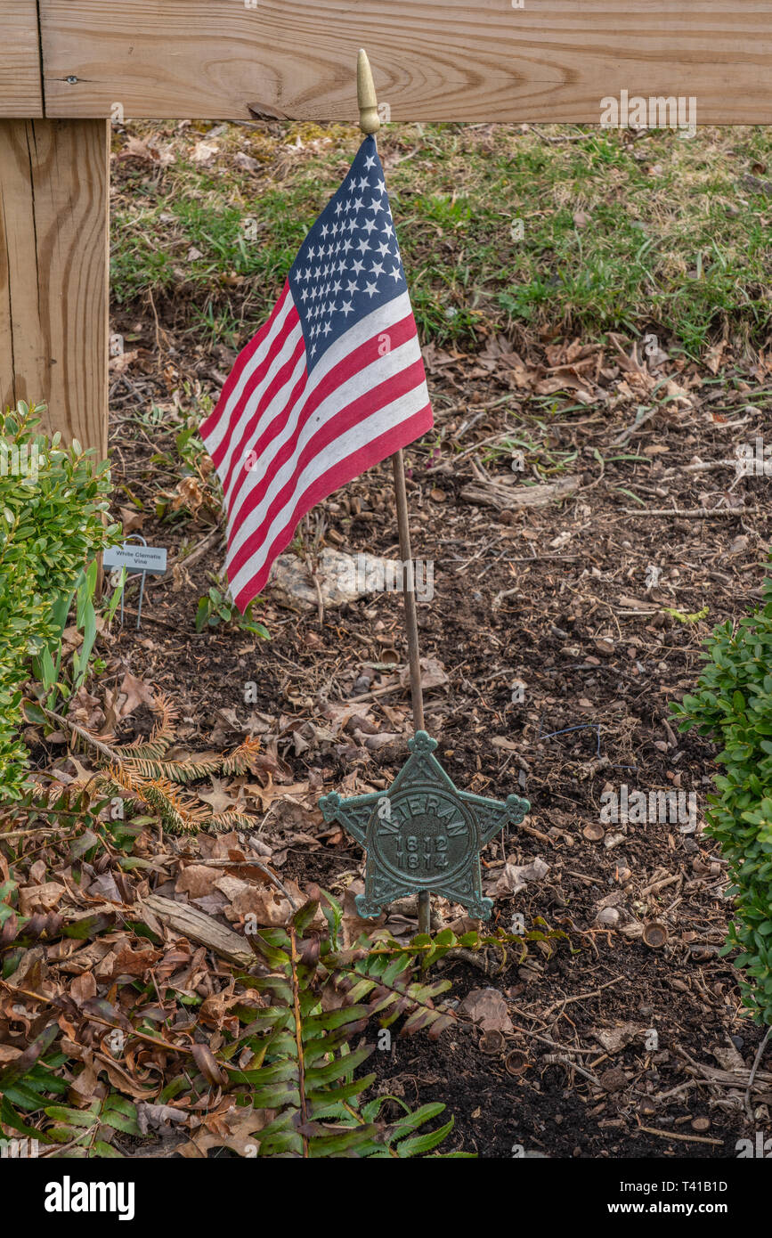 Perkasie, PA - 7. April 2019: Krieg von 1812 Memorial Medaillon hält eine amerikanische Flagge im Menlo Park Memorial Garden. Stockfoto