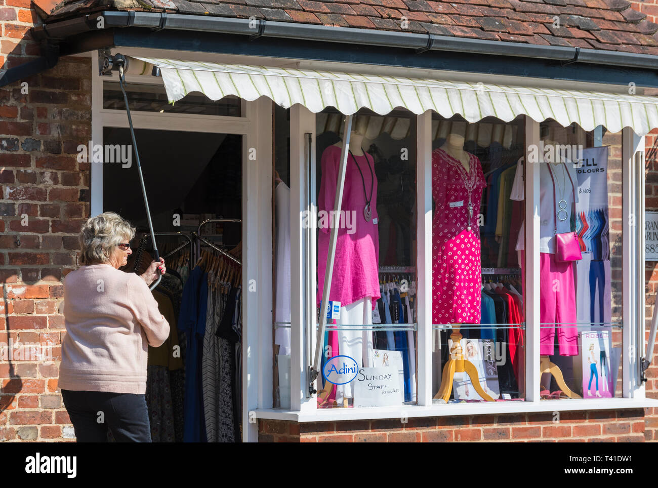 Frau Erweiterung Markise außerhalb eines kleinen unabhängigen lokalen Clothing Store in Großbritannien. Stockfoto