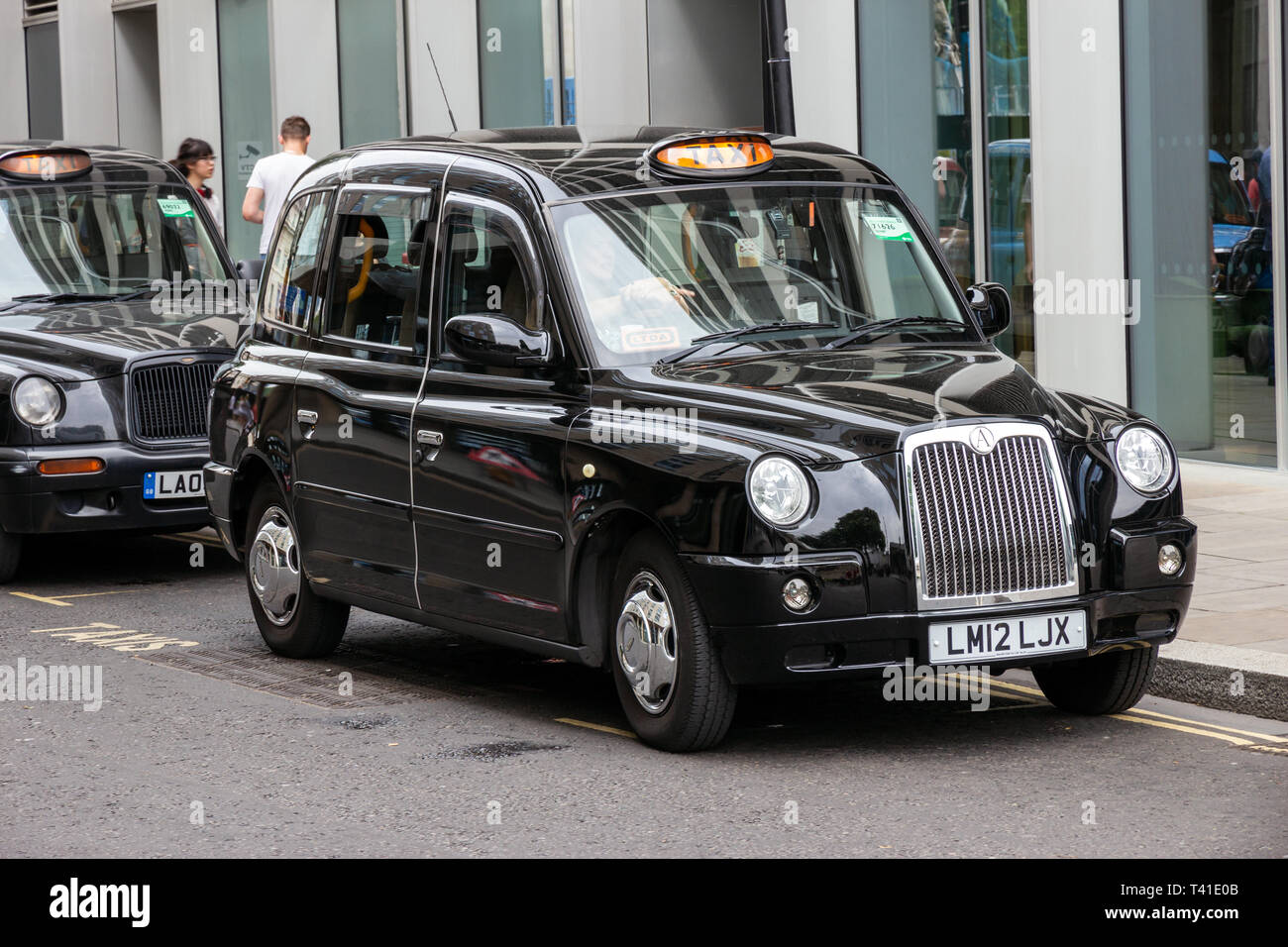 LONDON - Apr 2, 2015: Zeile von London Taxis aufgereiht auf dem Gehweg. Die berühmten schwarzen Taxis sind ein Symbol für die Stadt und eine große Attraktion in der Themse Stockfoto