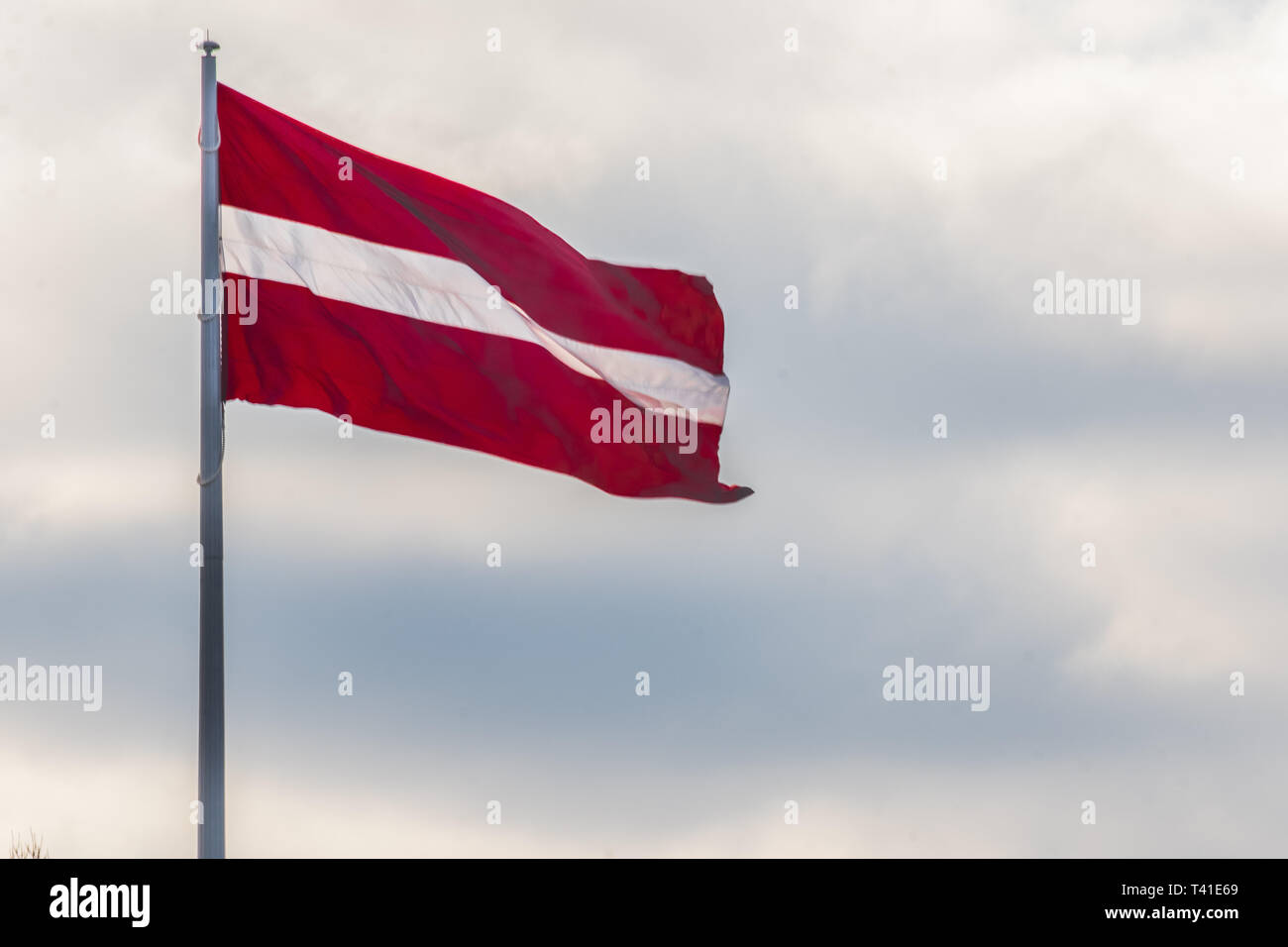 Große lettische Flagge mit den Wolken im Hintergrund Stockfoto