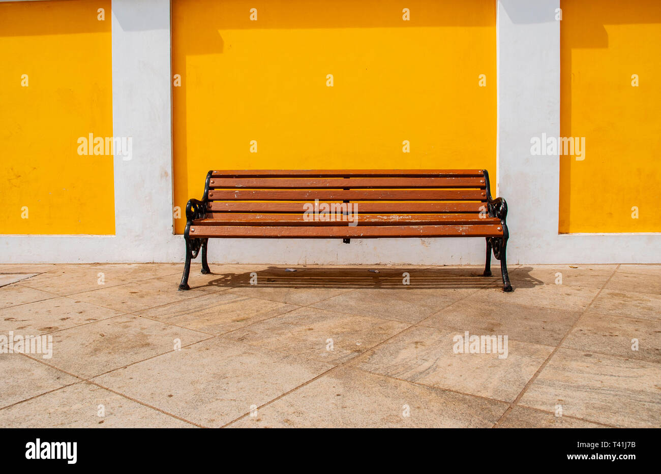 Sitze gegen Yello Wand in Pondicherry, Indien Stockfoto
