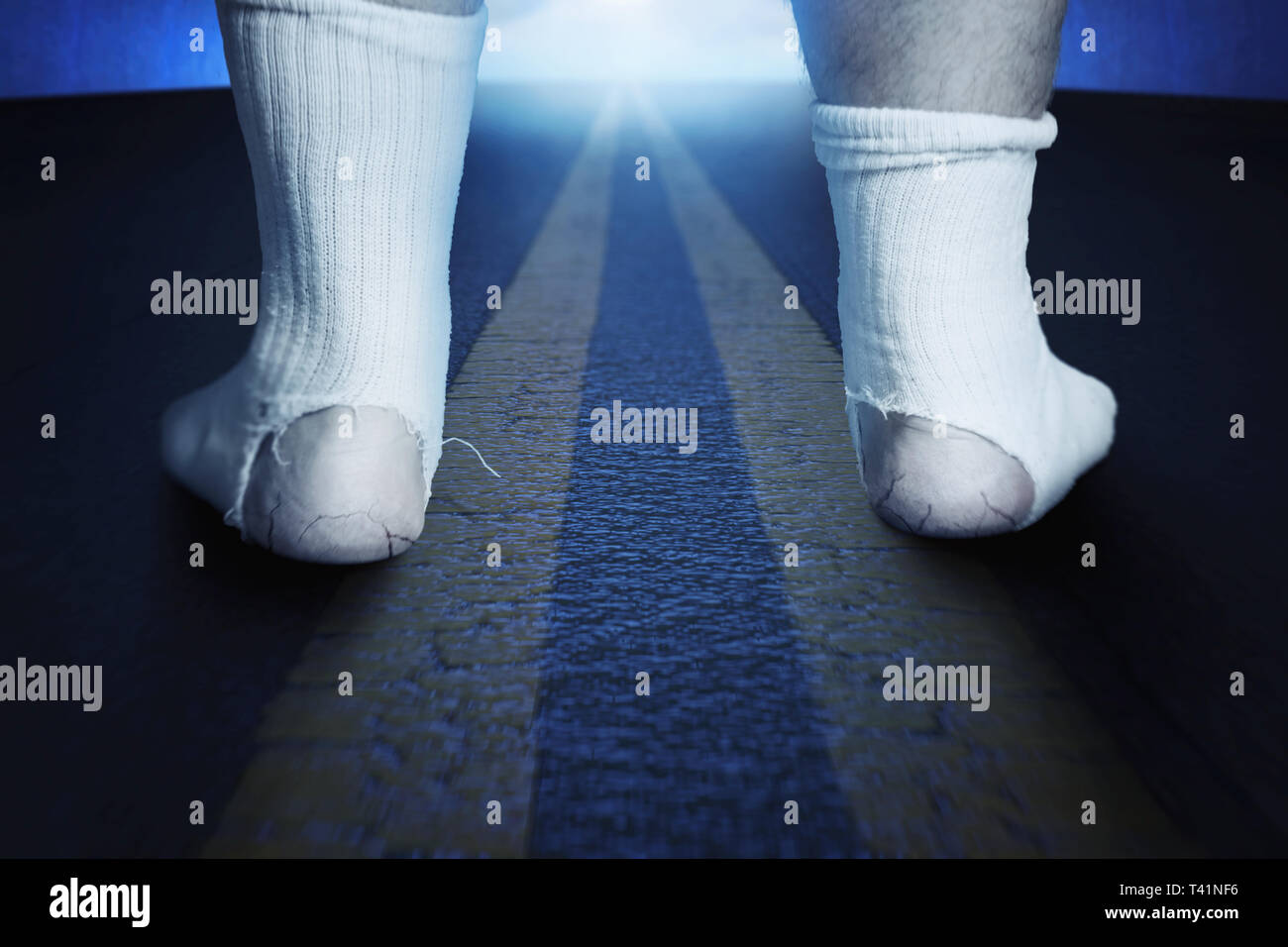 Rückseite des ständigen Füße mit weißen Socken und ein großes Loch auf Asphalt in der Nacht Stockfoto