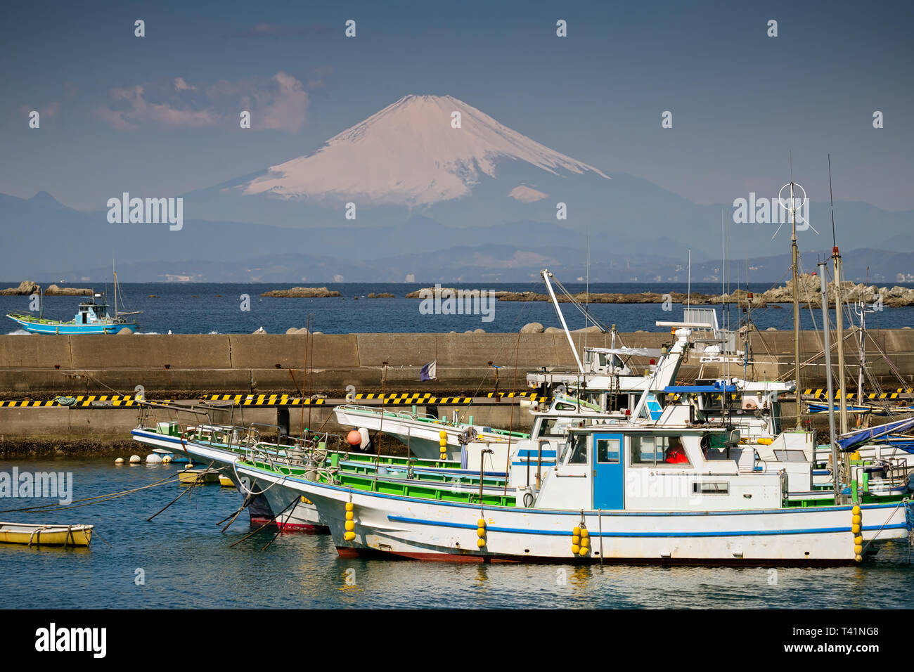 Fischerboote in einem kleinen Hafen in Hayama, Japan mit dem Berg Fuji im Hintergrund. Stockfoto