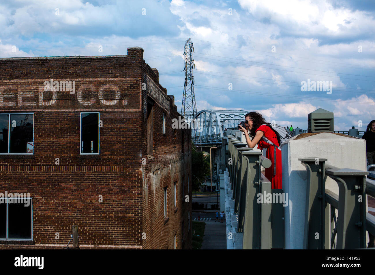 Eine Frau Fotograf steht auf einer Brücke ihre Kamera mit Schwerpunkt Stockfoto
