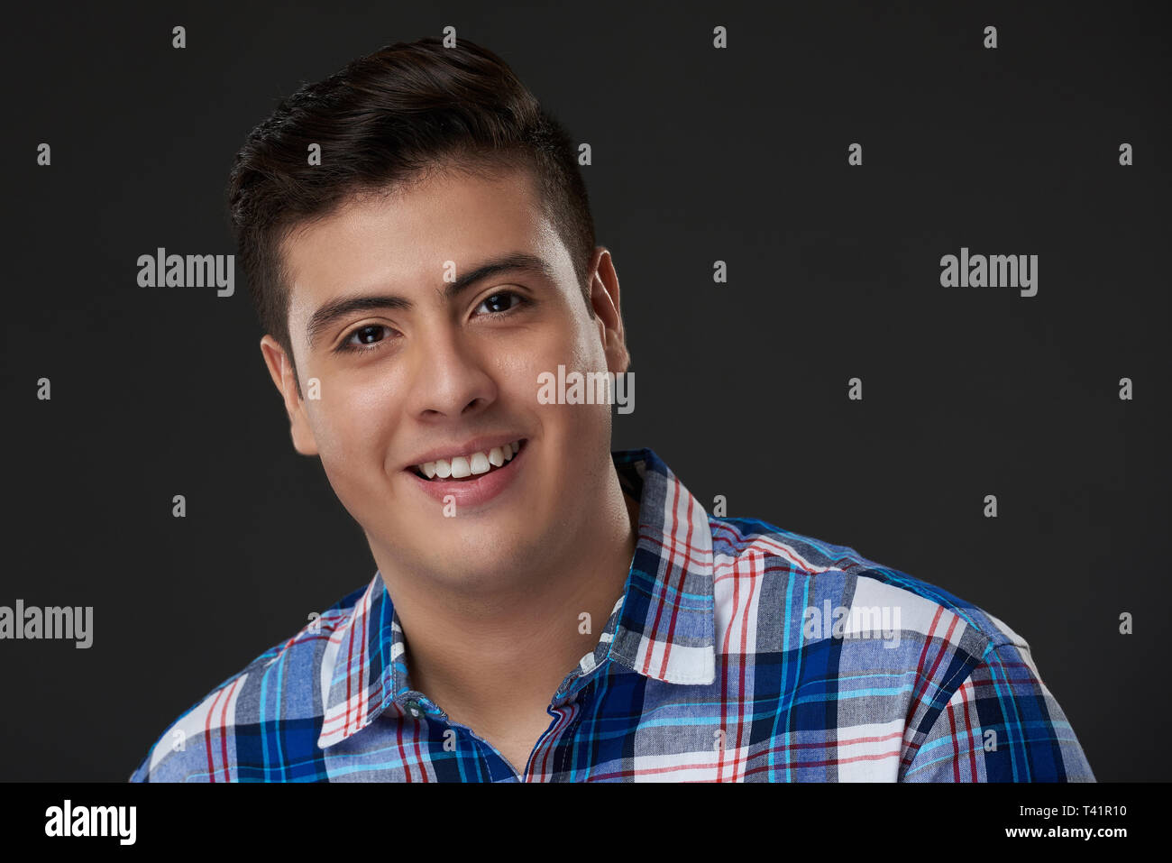 Headshot von Happy Hispanic junger Mann auf Grau studio Hintergrund isoliert Stockfoto