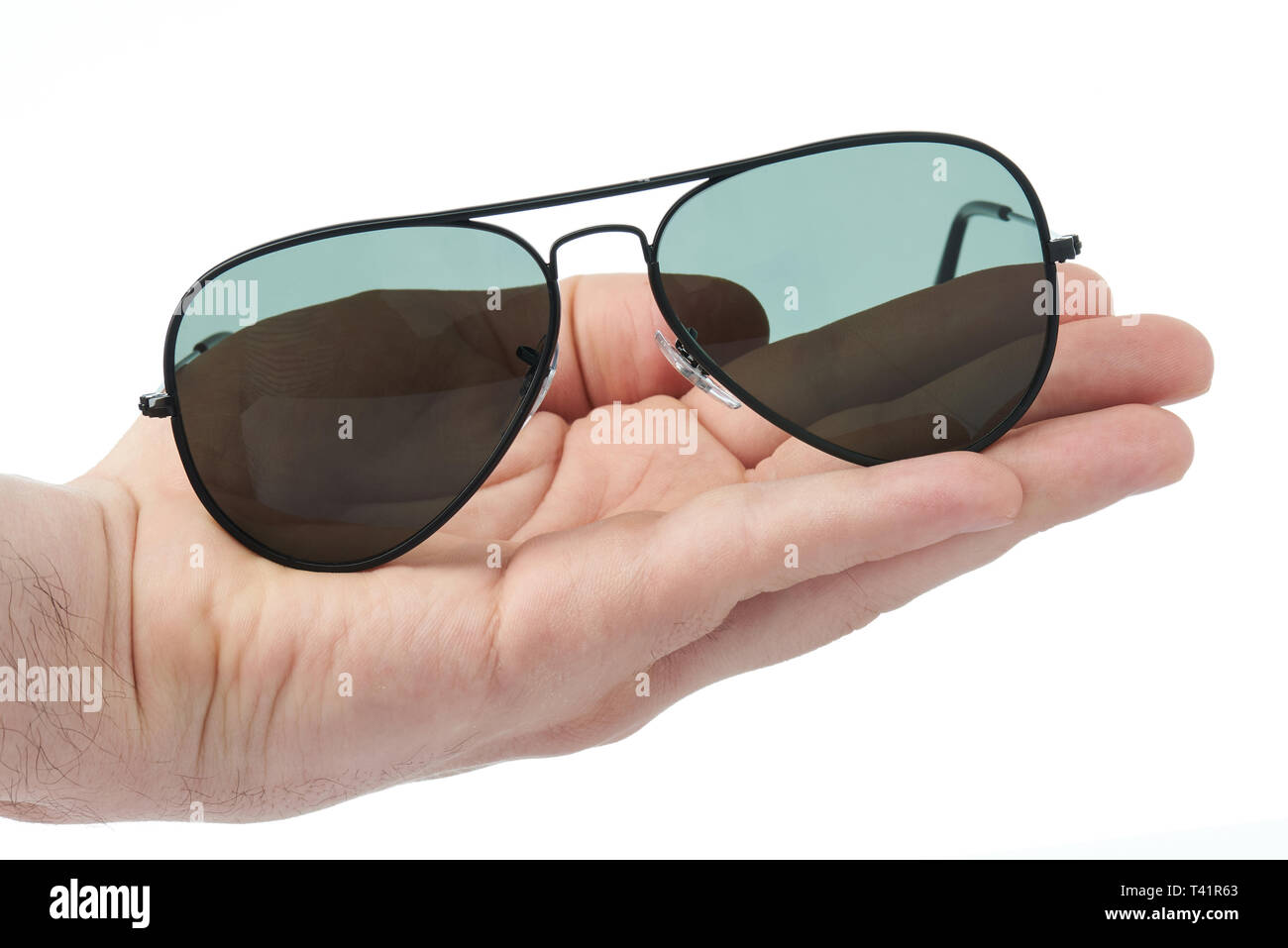 Schwarze Sonnenbrille in der Hand close-up auf weißem Hintergrund Stockfoto