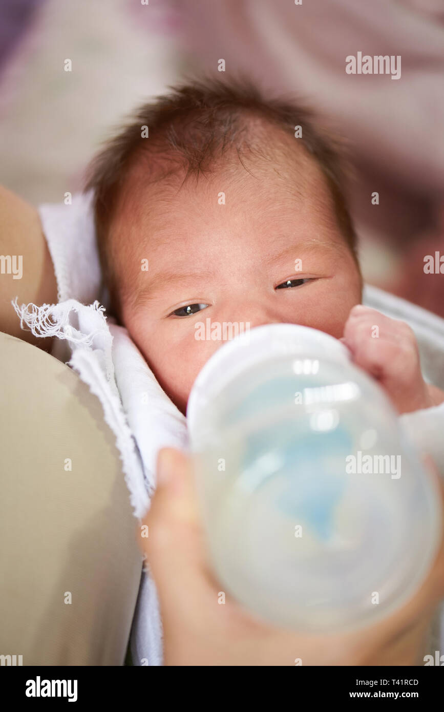 Neugeborenes Baby trinken Milch aus der Flasche schließen nach oben Stockfoto