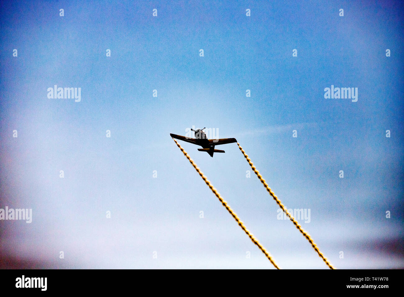 Flugzeug mit gelben Rauch Linien Stockfoto