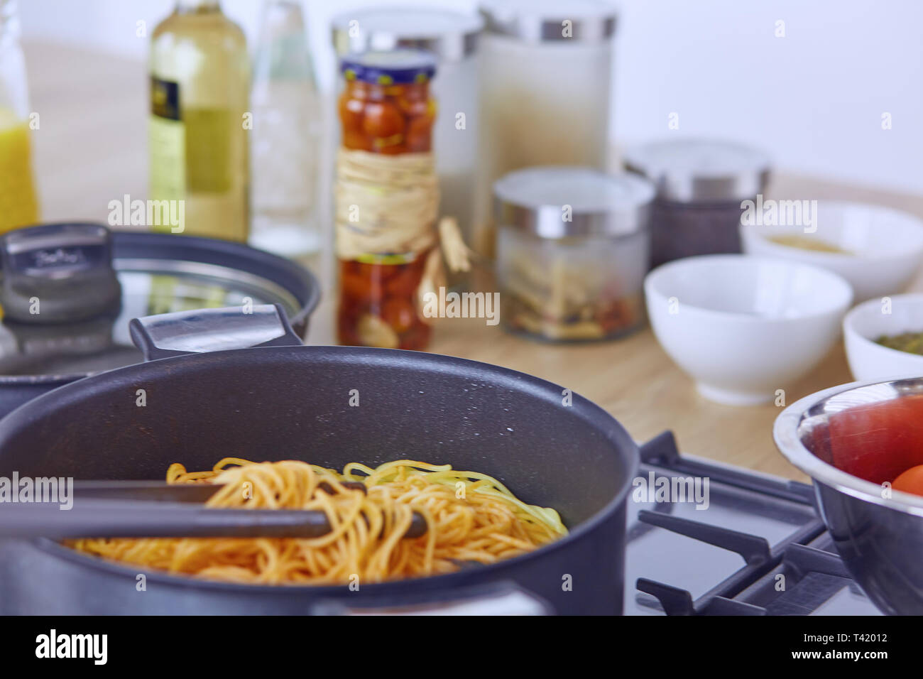 Pasta rollte auf Gabel über Pan am Herd in der Küche. Stockfoto
