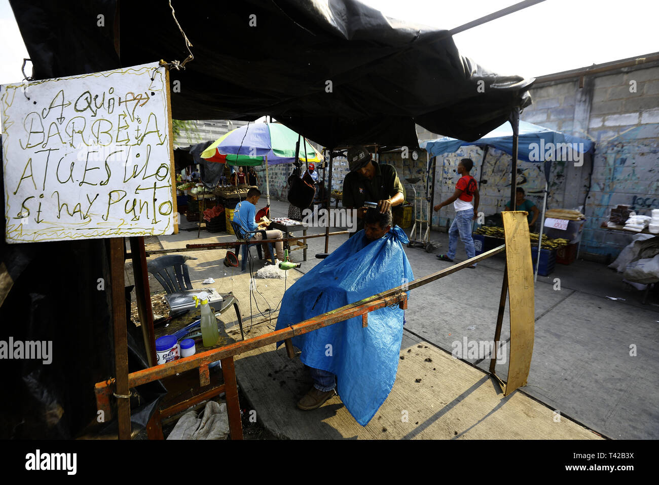 Valencia, Carabobo, Venezuela. 11 Apr, 2019. Pril 11, 2019. Gregory Hernandez, ist eine junge Venezolanische, die nicht mehr einen Job als Maurer, der seit vielen Jahren gewidmet war, beschlossen, eine lokale Straße, zu improvisieren und der Friseur- Service an solicarios Preise anbieten, die nach seinen eigenen Worten mindestens hilft Essen für Ihre Familie erhalten. Akzeptiert abgesehen von Bargeld oder elektronisches Geld, Pakete von Reis, Brot, Mehl, Teigwaren und anderen Lebensmitteln. Das Foto wurde auf Arantzasu Avenue, südlich der Stadt Valencia, Carabobo Zustand. Foto: Juan Carlos Hernandez (Credit Bild: © Juan Carlos Stockfoto